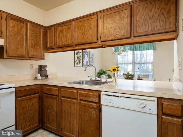 kitchen with dishwasher, range, a chandelier, kitchen peninsula, and sink