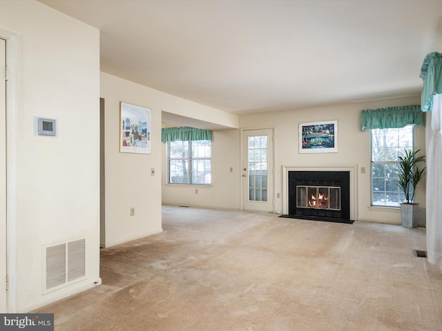 unfurnished living room featuring light colored carpet