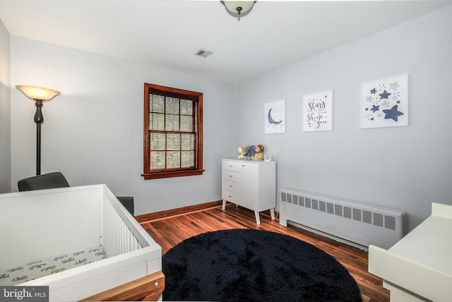 4901 Stillwell Ave, Alexandria, VA 22309 - bedroom with radiator heating unit, visible vents, baseboards, and wood finished floors