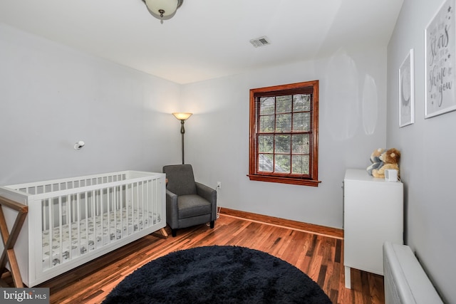 4901 Stillwell Ave, Alexandria, VA 22309 - bedroom with baseboards, radiator heating unit, wood finished floors, and visible vents