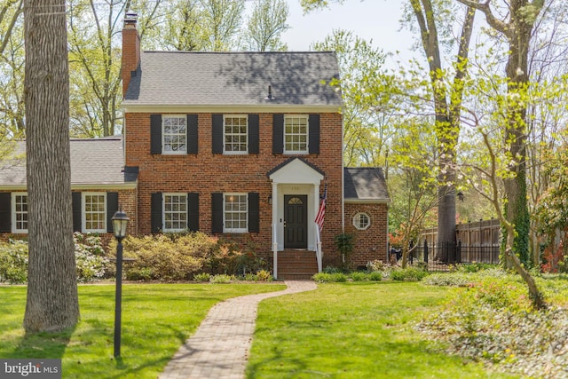 4901 Stillwell Ave, Alexandria, VA 22309 - colonial inspired home featuring a chimney, fence, brick siding, a shingled roof, and a front yard