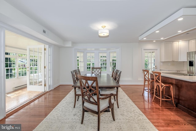 4901 Stillwell Ave, Alexandria, VA 22309 - dining room featuring a baseboard radiator, wood finished floors, a wealth of natural light, and recessed lighting