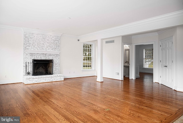 unfurnished living room featuring plenty of natural light, wood finished floors, and visible vents