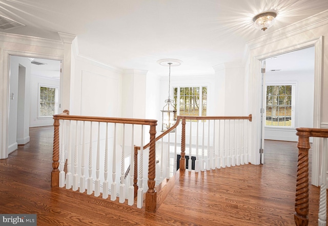 hallway with ornamental molding, visible vents, an upstairs landing, and dark wood-style floors