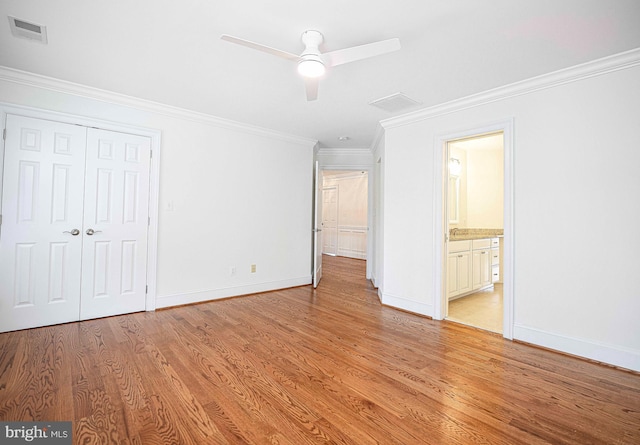 unfurnished bedroom featuring visible vents, baseboards, ornamental molding, a closet, and light wood-type flooring