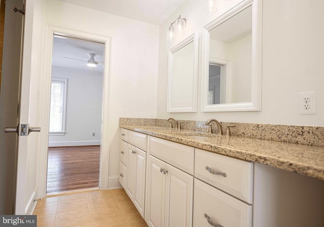 bathroom with vanity, baseboards, and tile patterned floors