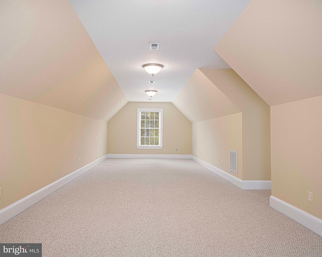 bonus room with light colored carpet, visible vents, lofted ceiling, and baseboards