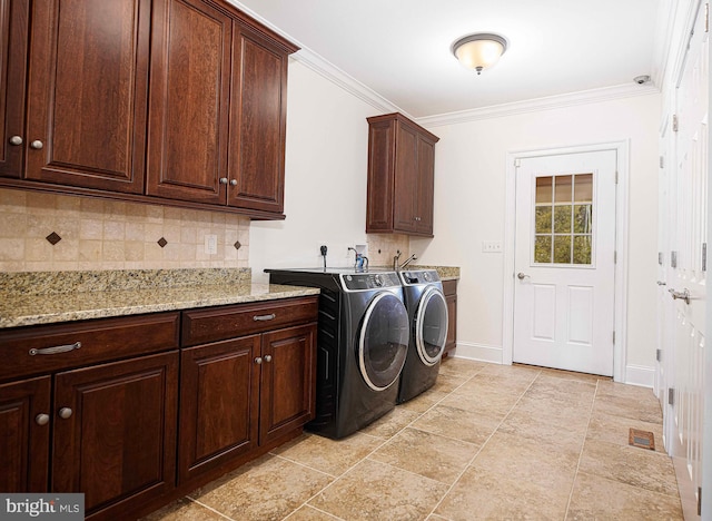 clothes washing area featuring ornamental molding, washer and clothes dryer, cabinet space, and baseboards