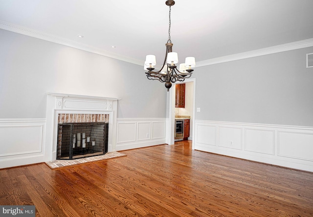 unfurnished living room featuring ornamental molding, visible vents, a fireplace, and wood finished floors