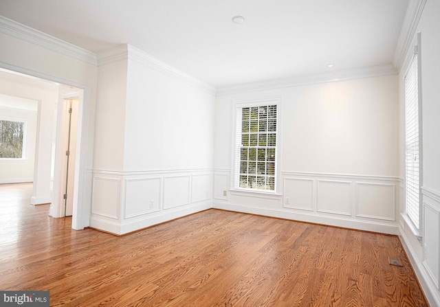 empty room featuring crown molding and light wood-style flooring