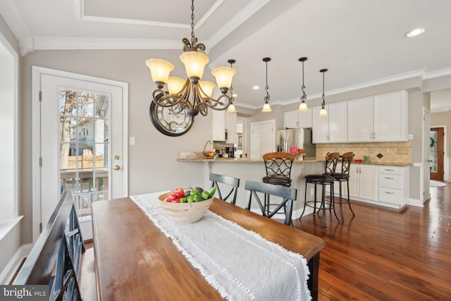 dining area featuring ornamental molding, dark hardwood / wood-style flooring, and a chandelier