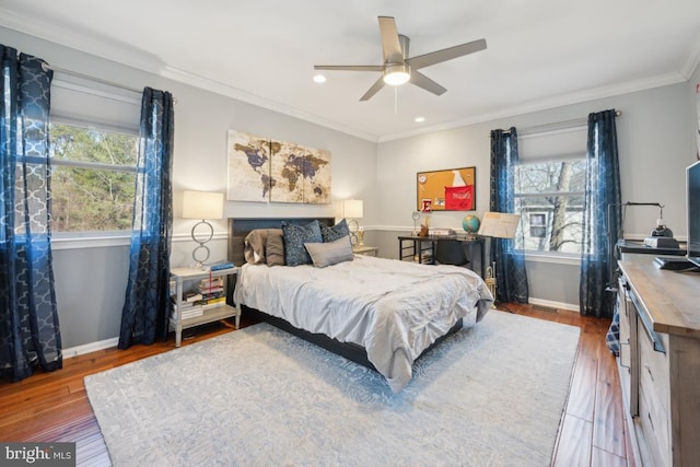 bedroom featuring multiple windows, crown molding, hardwood / wood-style flooring, and ceiling fan