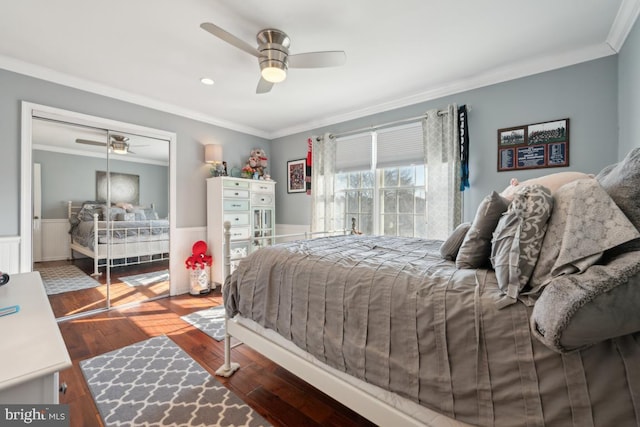 bedroom featuring crown molding, wood-type flooring, ceiling fan, and a closet