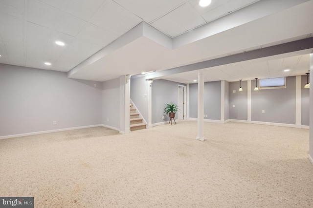 basement featuring carpet flooring and a drop ceiling