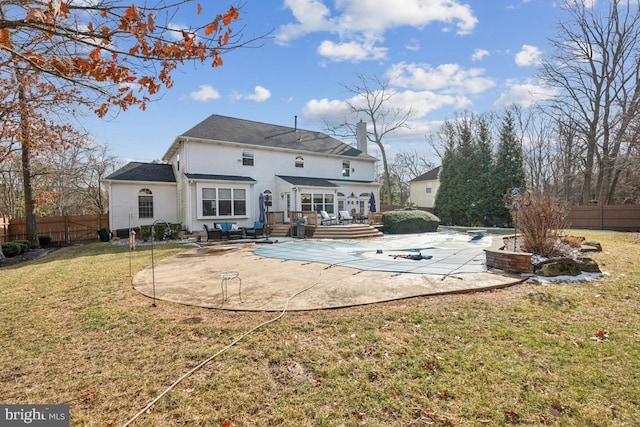 rear view of house with a swimming pool side deck, a yard, and a patio area