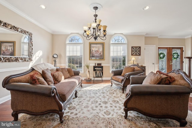 living room with dark wood-type flooring, crown molding, french doors, and a notable chandelier