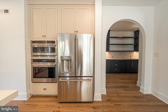 kitchen featuring hardwood / wood-style flooring, stainless steel appliances, and tasteful backsplash