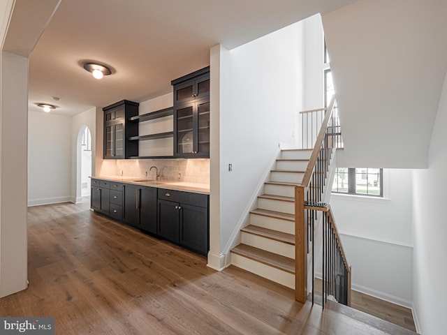 bar featuring hardwood / wood-style flooring, sink, and backsplash