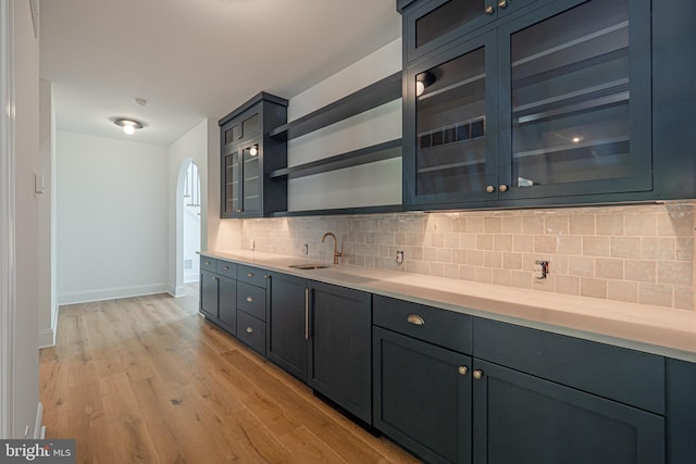 kitchen featuring backsplash, light hardwood / wood-style flooring, and sink