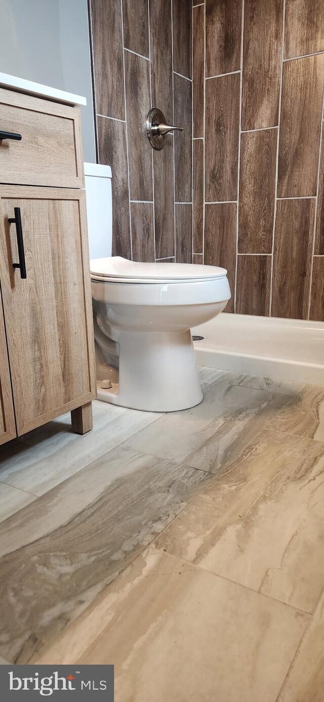 bathroom featuring walk in shower and toilet