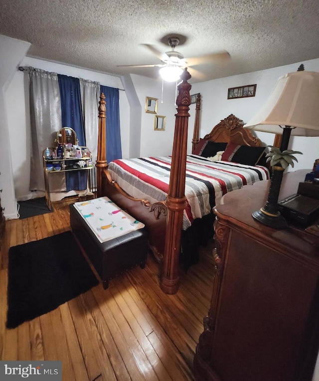 bedroom featuring hardwood / wood-style flooring, a textured ceiling, and ceiling fan