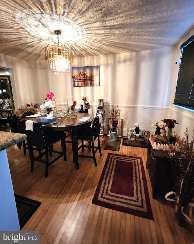 dining room featuring hardwood / wood-style flooring and an inviting chandelier