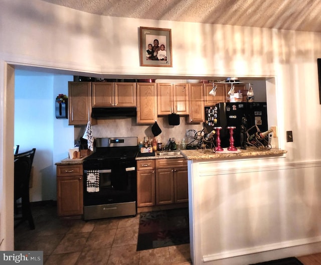 kitchen with black refrigerator, sink, and stainless steel stove