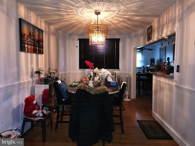 dining space with hardwood / wood-style flooring and an inviting chandelier