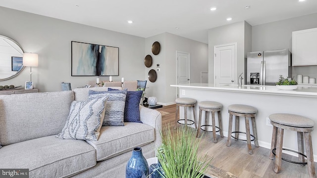 living room featuring light wood-type flooring and sink