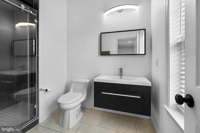 bathroom featuring vanity, tile patterned flooring, a shower with shower door, and toilet