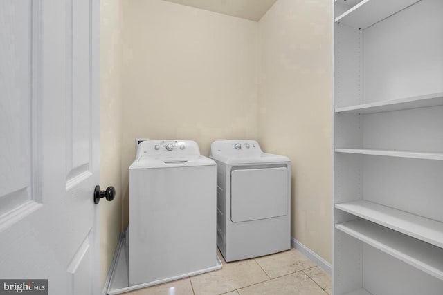 laundry area featuring washing machine and dryer and light tile patterned floors