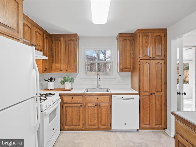 kitchen featuring sink, backsplash, and white appliances