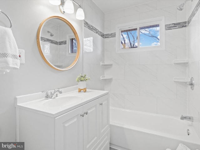 bathroom with tiled shower / bath combo and vanity