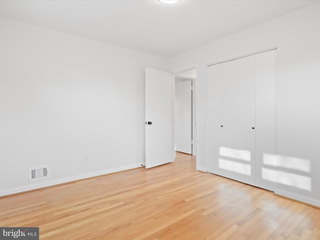 unfurnished bedroom featuring light hardwood / wood-style flooring and a closet