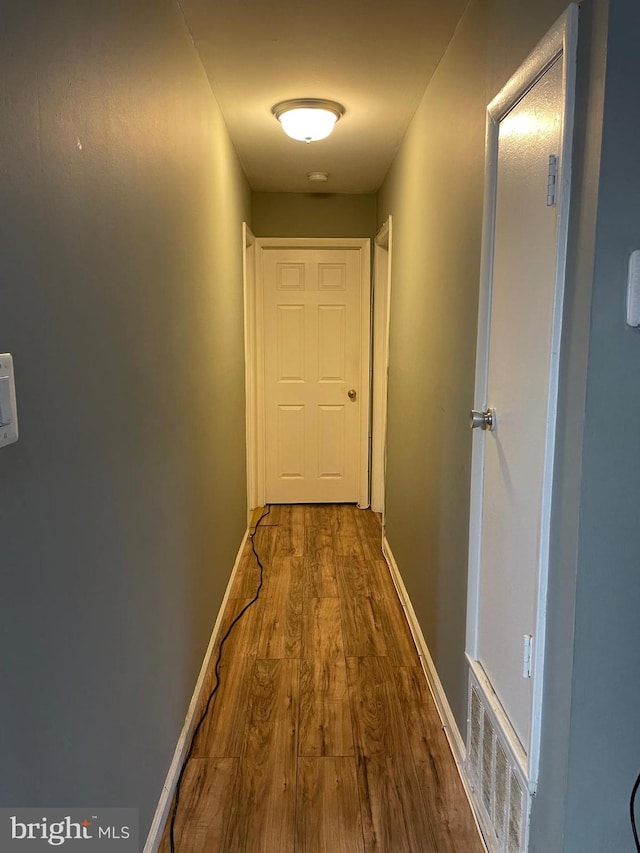 corridor with hardwood / wood-style floors