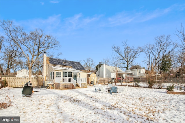 snow covered property with solar panels