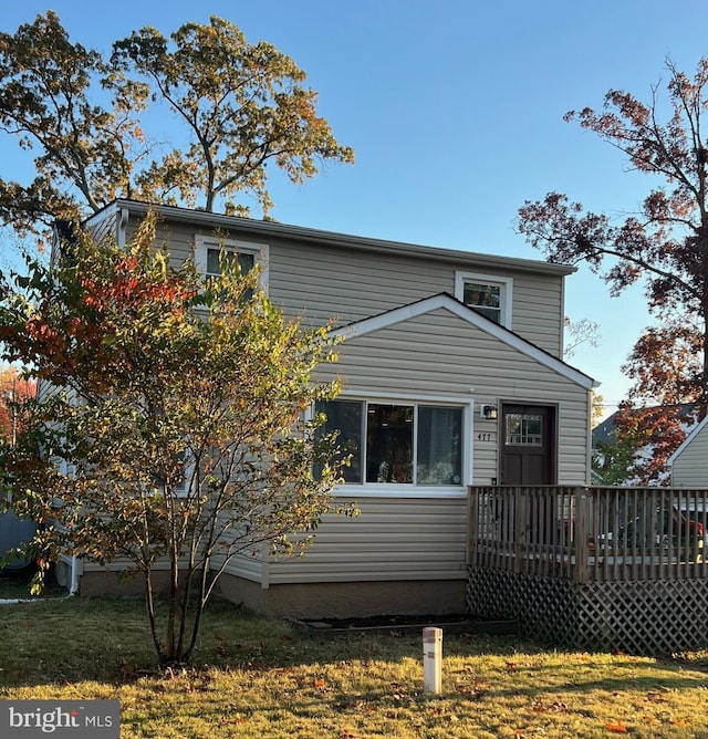 view of front of house featuring a deck and a front lawn