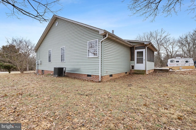 view of side of property with cooling unit and a yard