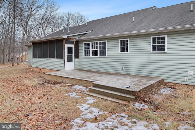 back of property featuring a wooden deck and a sunroom