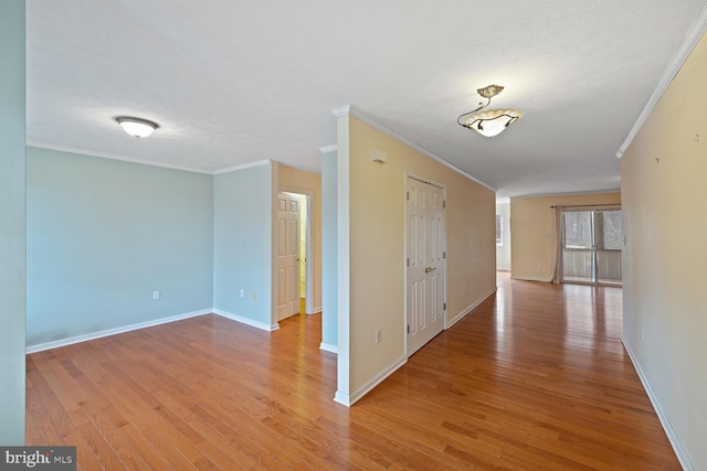 hallway featuring ornamental molding, a textured ceiling, and light hardwood / wood-style floors