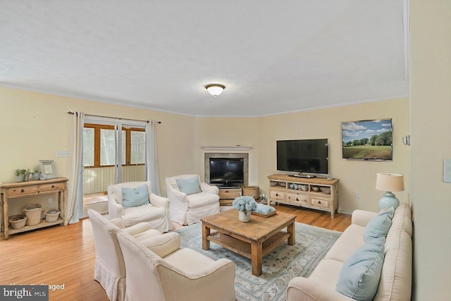 living room with ornamental molding and light hardwood / wood-style floors