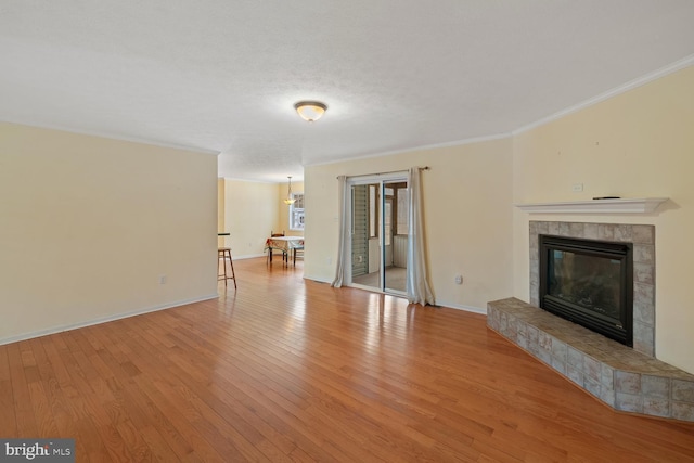 unfurnished living room featuring a fireplace, crown molding, and light hardwood / wood-style flooring