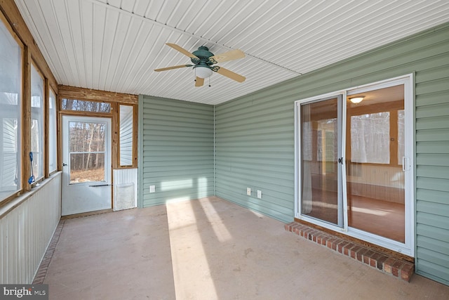 unfurnished sunroom featuring ceiling fan