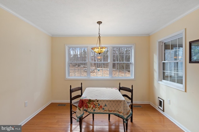 dining room featuring ornamental molding and light hardwood / wood-style flooring