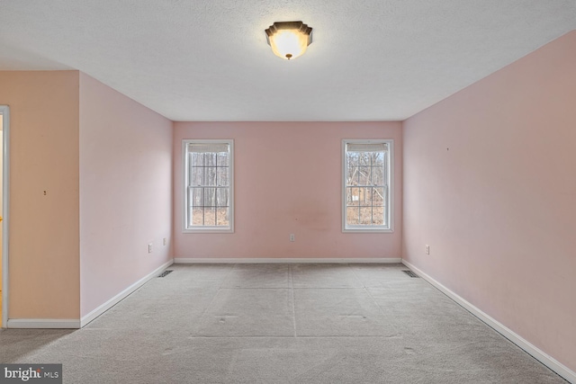 carpeted spare room with a textured ceiling