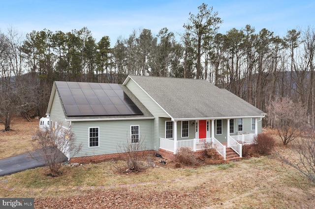 view of front of property featuring a porch and solar panels