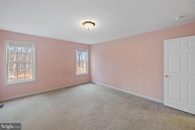 carpeted spare room with a textured ceiling