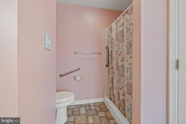 bathroom featuring a shower with curtain and toilet