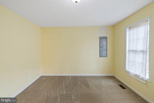 unfurnished room featuring light colored carpet and electric panel