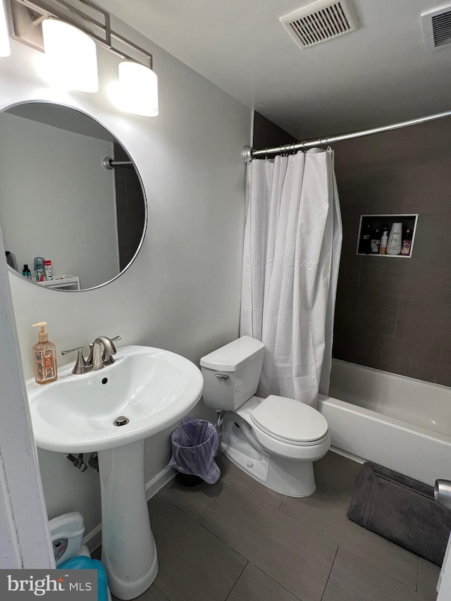 bathroom with toilet, tile patterned flooring, and shower / bath combo